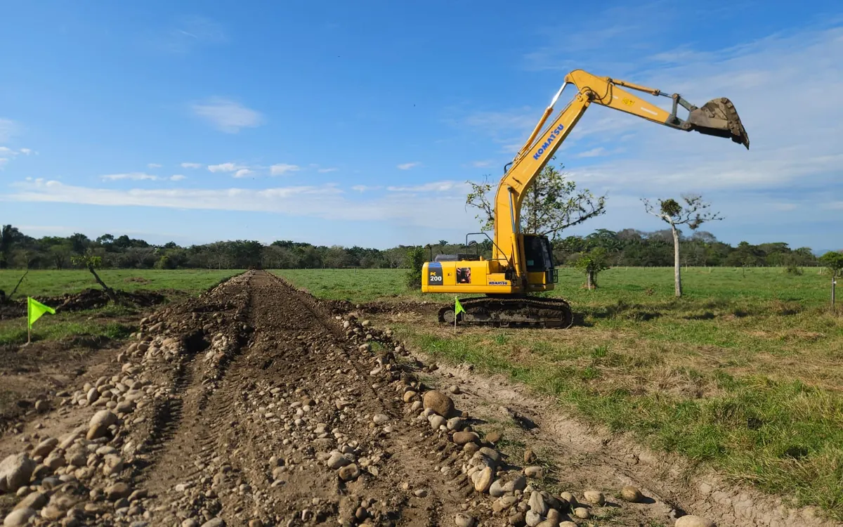 Excavadora acomodando el material de base de una vía interna